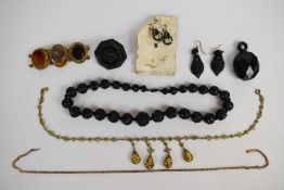 Four pieces of jet jewellery including carved beaded necklace, carved earrings, brooch carved with