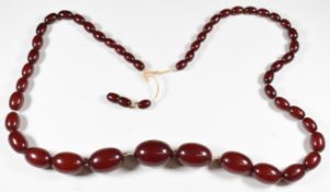 Cherry amber necklace made up of 48 graduated oval beads, the smallest 7 x 11mm and largest 21 x