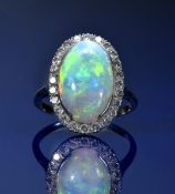 A platinum ring set with an opal cabochon of approximately 4.3ct surrounded by 24 round cut