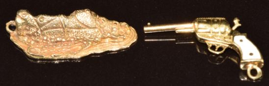 A 9ct gold charm in the form of Gibraltar (4.3g, 2.5cm) and a 14k gold charm in the form of a pistol