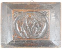Likely 17th century carved oak panel decorated with a jester or similar contorted man, 24 x 31cm