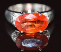 An 18k gold ring set with an oval cut Padparadscha sapphire of approximately 4ct, 6.9g, size N
