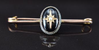 Victorian 9ct gold brooch set with a foiled garnet and seed pearl to the centre in a star setting,