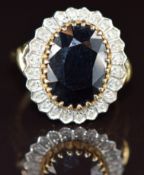 A 9ct gold ring set with an oval cut sapphire surrounded by diamonds totalling approximately 0.12ct,