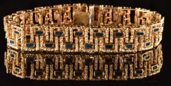 A 9ct gold bracelet with textured decoration, set with rectangular panels of blue enamel, 32.7g,