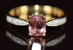 An 18k gold ring set with a cushion cut imperial topaz of approximately 1ct and with diamonds to the