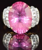 An 18ct gold ring set with an oval mixed cut pink topaz and with diamonds to the shoulders, 10.1g,