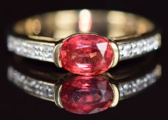 A 9k gold ring set with an oval cut Tanzanian ruby of approximately 0.99ct and white sapphires, 2.