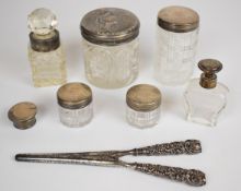 Six Victorian and later hallmarked silver mounted and lidded glass dressing table pots and bottles