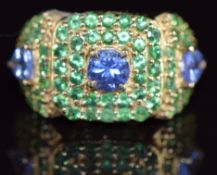 A 9k gold ring set with a round cut tanzanite of approximately 0.6ct, two trilliant cut