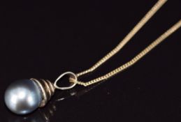 A 14k rose gold pendant set with a black pearl (3.3g, 10.5mm) on 9ct gold chain (2.1g)