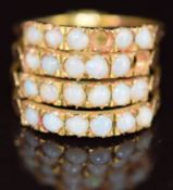 A 9ct gold ring made up of four bands, each set with six opals (one opal missing), 3.3g, size L