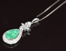 An 18k white gold pendant set with a pear cut emerald of approximately 1.9ct surrounded by round and