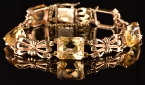 A 9ct gold bracelet set with mixed emerald cut citrines and bow shaped links (one loose), 14.3g,