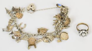A silver charm bracelet with twenty one silver charms including fish, clock, penguin, swallow, etc