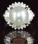 A platinum ring set with a South Sea pearl (10.5mm) surrounded by baguette and round cut diamonds,