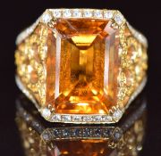 An 18k gold ring set with an emerald cut citrine of approximately 10ct with diamonds and yellow