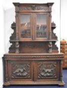 Victorian breakfront carved oak glazed bookcase over two drawers and twin cupboard with hunting