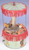 Tinplate clockwork musical carousel with green painted base, canopy, turned wooden figures, fabric