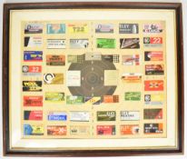 A framed display of rifle cartridge box lids mounted on a rifle shooting target, 60 x 71cm.