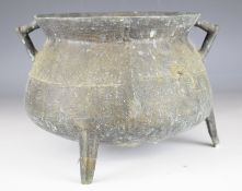 Chinese bronze twin handled cauldron raised on three legs, 46cm in diameter.
