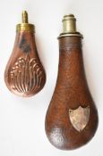 Two powder flasks comprising a G & JW Hawksley flask with leather covering and applied shield