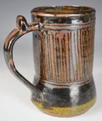 Ladi Kwali (Nigerian 1925-1984) studio pottery tenmoku glazed tankard with artist's seal, height