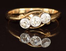 An 18ct gold ring set with three diamonds in a platinum twist setting, 2.6g, size L