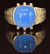 A 9ct gold ring set with a blue agate cabochon, with engraved decoration to the shoulders, 3.6g,