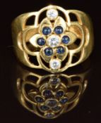 An 18ct gold ring set with cubic zirconia and paste in a pierced floral setting, 3.5g, size M