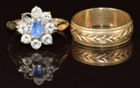 A 9ct gold wedding band with cut out decoration and a 9ct gold ring set with a sapphire surrounded