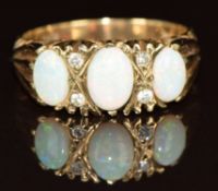 A 9ct gold ring set with three oval cut opal cabochons and four diamonds, 3.5g, size P