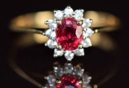 A 9k gold ring set with an oval cut Malawi ruby of approximately 0.4ct surrounded by zircons, 1.