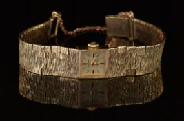 Bulova 9ct gold ladies wristwatch with black hands and baton hour markers, silver dial and signed 17