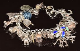 A silver charm bracelet with over twenty eight silver charms, 77.5g