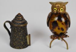 Two novelty sewing tape measures, one as an owl the other a flagon with repoussé decoration, tallest