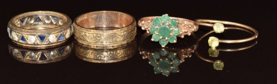 Four 9ct gold rings comprising eternity ring, emerald cluster, wedding band / ring and peridot, 10.