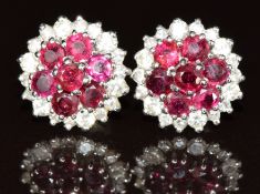 A pair of 18ct white gold earrings each set with a cluster of rubies surrounded by diamonds, 8.5g
