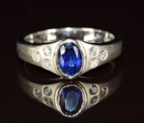 An 18k white gold ring set with an oval cut sapphire of approximately 0.8ct with three diamonds to