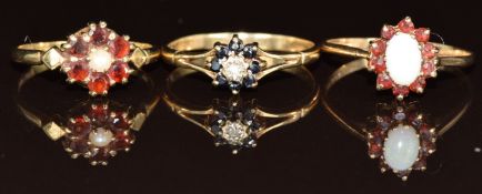 Three 9ct gold rings set with an opal surrounded by garnets, a pearl surrounded by garnets and a