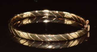 A 9ct gold bangle with ridged decoration, 9.6g, 6.1 x 5.2cm