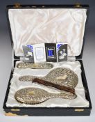 Elizabeth II cased hallmarked silver dressing table set comprising hand mirror, two brushes and