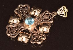 A yellow metal pendant in the form of a cross set with a synthetic blue spinel, testing as 14k