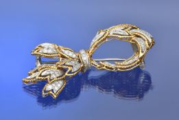 A c1950 18k gold bi-coloured brooch in the form of a stylised bow set with diamonds, 18.5g, 5.8cm