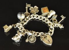 A silver charm bracelet with twelve charms including ten shilling note, four leaf clover, etc, 61g