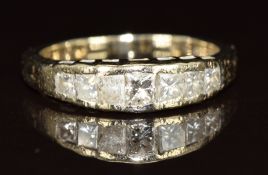 An 18k white gold ring set with graduated princess cut diamonds, 3.6g, size K
