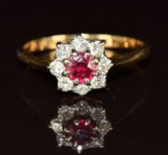 An 18ct gold ring set with a round cut ruby surrounded by diamonds, 2.3g, size N