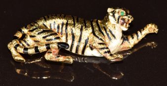 An 18ct gold brooch in the form of a tiger set with emerald eyes and black and white enamel,