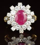 An 18ct gold ring set with an oval cut ruby of approximately 1.7ct surrounded by diamonds, the total