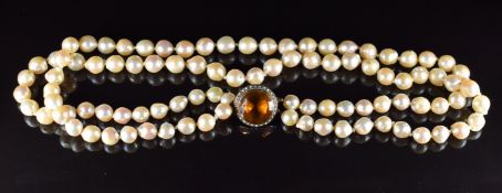 A double strand of cultured pearls, the 9ct gold clasp set with an oval cut citrine surrounded by
